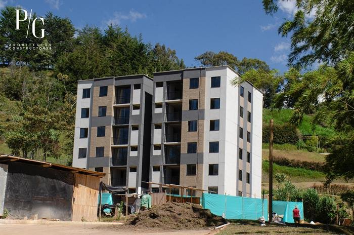 Vista general del edificio de Guaduales de Vista Hermosa en obra, rodeado de montañas del Oriente Antioqueño